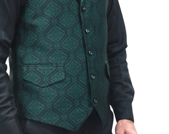 May include: A dark green vest featuring a black repeating geometric pattern, a notched lapel, and five black buttons down the front. The vest includes two front pockets with flaps and is worn over a solid black long-sleeved shirt and black trousers.