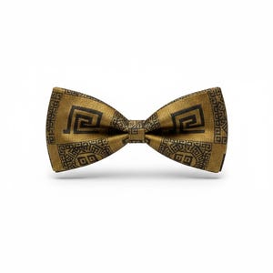 May include: A gold-colored bow tie with a repeating black geometric pattern. The bow tie is centered and isolated on a white background. The fabric has a subtle sheen, suggesting a formal or dressy style.