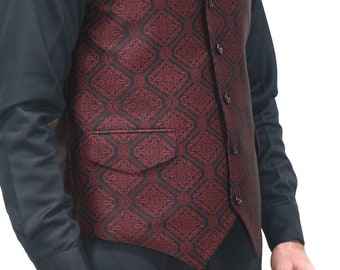 May include: A vest featuring a deep red and black intricate geometric pattern. The garment has a notched lapel, a single-breasted front with four visible buttons, and a single welt pocket with a flap on the lower front side of the vest.