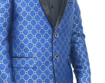 May include: A vibrant blue blazer featuring a repeating gold geometric pattern, a black satin shawl lapel, and two front buttons. The jacket includes a black chest pocket square and black pocket flaps, worn over a black button-down shirt.
