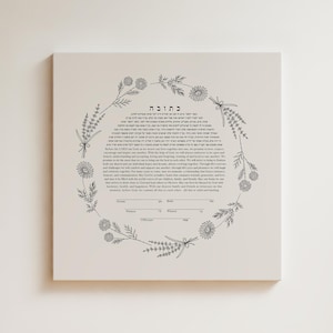 May include: A square ketubah featuring a central block of Hebrew and English text surrounded by a circular wreath of black line-art wildflowers and herbs. The document includes blank lines for signatures of the groom, bride, and witnesses.