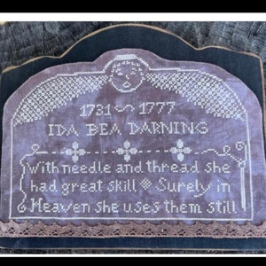 May include: A framed cross-stitch sampler with the text "1731-1777 IDA BEA DARNING". The sampler features a decorative border and the inscription "With needle and thread she had great skill. Surely in Heaven she uses them still."