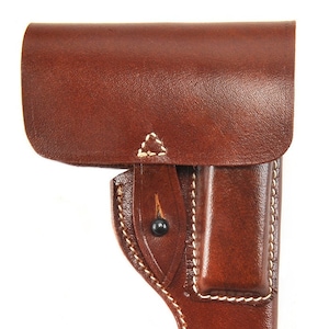 May include: A brown leather holster with white stitching. The holster has a flap with a snap closure and a belt loop.