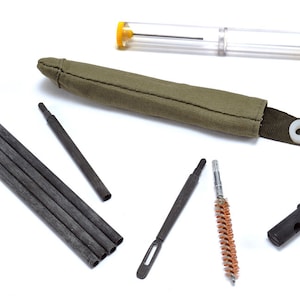 May include: A cleaning kit for a firearm, including a cleaning rod, a brush, a pick, and a storage case. The kit is made of metal and plastic.