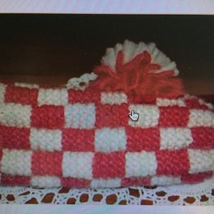 May include: Red and white checkered knitted slipper with a white pom-pom on top.