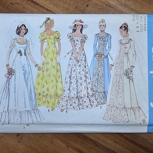 May include: A Simplicity 6888 sewing pattern envelope featuring illustrations of five different floor-length dresses. The designs include various necklines, sleeve lengths, and floral or solid patterns, with some figures wearing veils or hats.