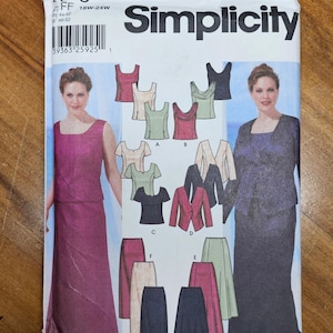 May include: A Simplicity sewing pattern envelope featuring illustrations of women's formal wear. The envelope includes images of tops, skirts, and jackets in various colors. The pattern number is 5973, and the size is 18W-24W.