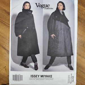 May include: A Vogue Patterns sewing pattern envelope for an Issey Miyake designer original coat, number 2978. The front shows two black and white photographs of a long, dark, oversized coat with a high collar, worn over dark trousers and shoes.