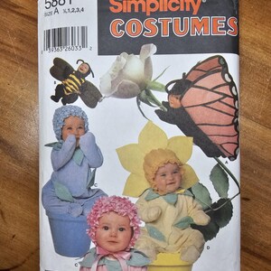 May include: A Simplicity Costumes sewing pattern envelope, number 5881, size A 1/2, 1, 2, 3, 4. The front features illustrations of infants wearing costumes including a bee, a butterfly, a blue flower, and a yellow flower, with a barcode and text.