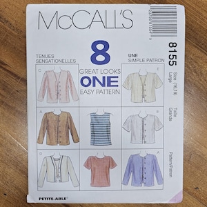 May include: A McCall's sewing pattern, featuring eight different garment designs. The pattern includes a variety of tops and jackets, with the size listed as Large (16,18). The package has the text "Great Looks One Easy Pattern".