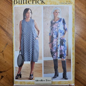 May include: A Butterick sewing pattern, B6784, featuring two dress designs. One dress is sleeveless with blue and white stripes, the other has a floral print with three-quarter sleeves. The pattern includes sizes X-Small to Medium.