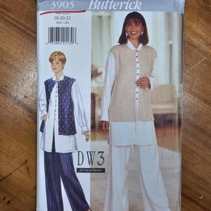 May include: Butterick sewing pattern 3905 for sizes 18-20-22, featuring a design by David Warren. The envelope displays illustrations of a long-sleeved shirt, a button-front vest, and wide-leg trousers in two color variations: navy blue with white pinstripes and solid beige.