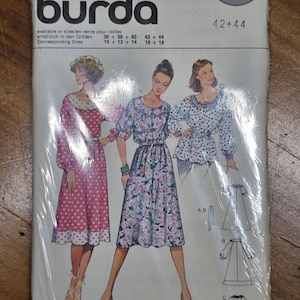 May include: A Burda sewing pattern packet featuring illustrations of three dresses. The packet is sealed in clear plastic. The text on the packet includes the Burda logo, pattern number 9963, and size information.