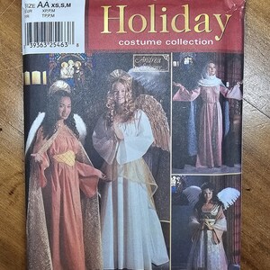 May include: A Simplicity 7033 Holiday costume collection sewing pattern envelope featuring illustrations of four different angel and historical-style costumes in various colors including white, pink, and gold with long flowing sleeves and wings.