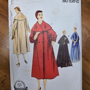 May include: Vintage Vogue Patterns envelope featuring illustrations of women's coats. The envelope is labeled "V1977" and "REISSUE CIRCA 1955 DESIGN." The size range is 16-18-20-22-24. The envelope is off-white with illustrations in various colors.