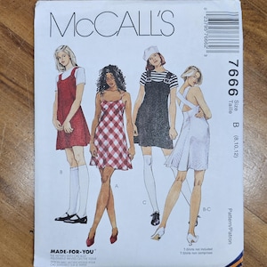 May include: A McCall's sewing pattern envelope featuring illustrations of four different dress designs. The envelope is white with the McCall's logo and pattern number 7666. The size is B (8,10,12).