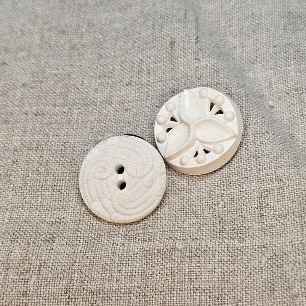 Vintage, white plastic buttons with interesting designs. Self shank, 7/8" (2.3cm). Lot of 2. Good vintage condition.