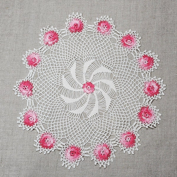 Stunning vintage doily. Bright pink 3D flowers surround dramatic swirled center. 12' white ground. Excellent condition. Repurpose? Upcycle?