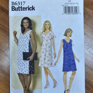 May include: Butterick B6317 sewing pattern featuring three dress designs. The pattern includes a dress with a black and white print, a floral print dress, and a blue lace dress. The pattern size is A5 (6-8-10-12-14).