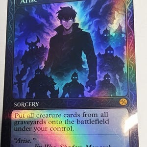 May include: A holographic trading card with the title "Arise" and a fantasy illustration of a character and shadowy figures. The card text reads "Put all creature cards from all graveyards onto the battlefield under your control."