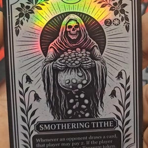 May include: A holographic trading card with a black and white illustration of a hooded skeleton holding a bag of coins. The card is titled "SMOTHERING TITHE" and includes game text. Floral and geometric border designs.