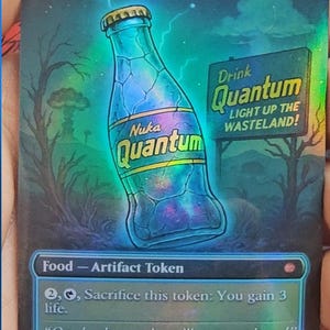 May include: A holographic card featuring a Nuka Quantum bottle with a cosmic interior, set against a post-apocalyptic landscape. The card includes the text "Drink Quantum" and "LIGHT UP THE WASTELAND!" and is labeled as a Food - Artifact Token.