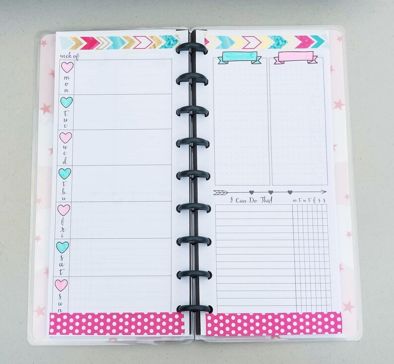 May include: A pink and white weekly planner with a section for "I Can Do That!" and a grid for daily tasks. The planner has a pink polka dot design and a pink and blue arrow design.