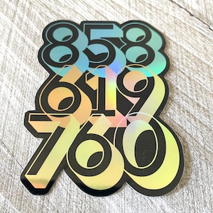 May include: A holographic sticker featuring the numbers 858, 619, and 760 in a layered, overlapping design. The numbers are black with a rainbow iridescent finish.