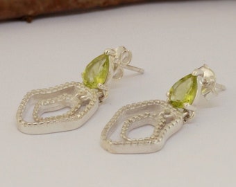 Puede incluir: Un par de pendientes de plata con una piedra preciosa verde en forma de pera que cuelga de cada uno. Los pendientes presentan un diseño delicado y calado.