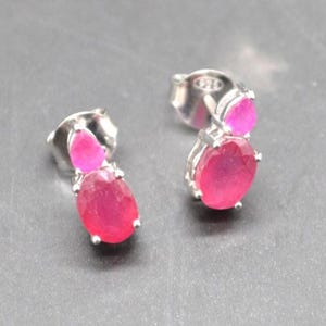 Peut inclure: Une paire de boucles d'oreilles à clous en argent avec deux pierres précieuses roses vives de forme ovale. Les boucles d'oreilles ont un fermoir à tige et sont serties dans de l'argent.