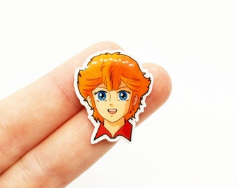 May include: A sticker featuring a cartoon character with orange hair, blue eyes, and a red shirt. The character is smiling and looking to the right.