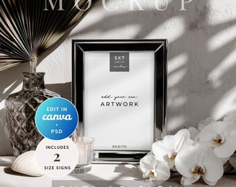 May include: A silver framed 5x7 inch sign mockup with the text "add your own ARTWORK". The image includes a vase, a seashell, a candle, and white orchids. The sign also includes the text "EDIT IN canva + PSD" and "INCLUDES 2 SIZE SIGNS".