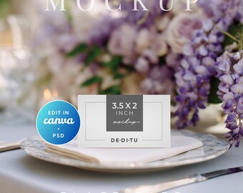 May include: A white place card mockup, 3.5 x 2 inches, on a plate with a floral design. The card is on a white napkin, with a blurred floral arrangement in the background. The text "MOCKUP" and "PLACE CARD" are visible.