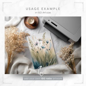 Puede incluir: Una impresi&oacute;n en acuarela de flores silvestres en tonos azules, morados y verdes, con el texto "USAGE EXAMPLE in ISO A4 size" y "add your own ISO ratio artwork". La impresi&oacute;n est&aacute; junto a una impresora, una vela y flores secas.