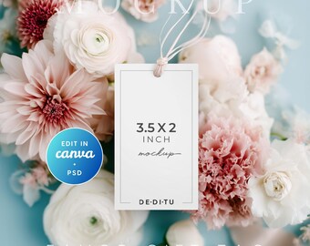 May include: A white rectangular favor gift tag mockup, 3.5 x 2 inches, with a string, set against a backdrop of pink and white flowers. The tag has the text "MOCKUP" at the top and "FAVOR GIFT TAG" at the bottom. The tag also has the text "3.5 X 2 INCH mockup".