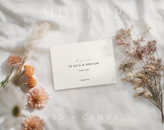 May include: A mockup featuring a white card with the text "add your own 10.5X14.8 DESIGN (ISO A6)" and the brand name "DEDITU". The card is surrounded by dried flowers in shades of peach, pink, and beige, arranged on a white fabric surface.