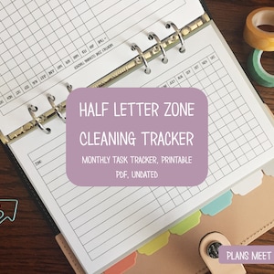 Op de afbeelding: Een planner met een schoonmaaktracker, met een raster voor maandelijkse taken. De tekst "HALF LETTER ZONE CLEANING TRACKER" wordt weergegeven op een paarse achtergrond. Inclusief washitape en paperclips.