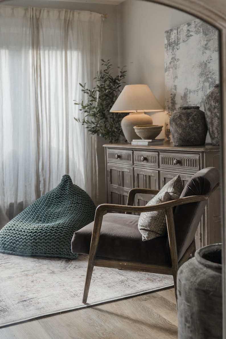 sage green knitted beanbag in the corner of a neutral earthy toned cottage interior living room space