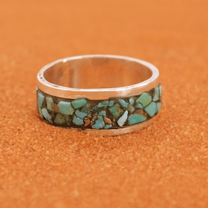 Peut inclure: Une bague en argent avec une bande de pierres turquoise serties dans une bande d'argent.