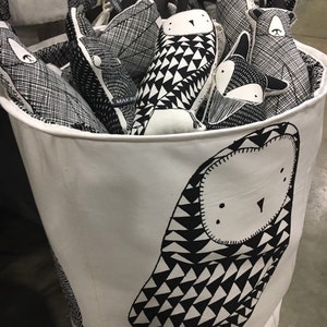 May include: A white canvas storage bin with black and white geometric owl print. The bin is filled with various black and white patterned stuffed animals.