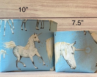 Peut inclure: Deux bacs de rangement en tissu bleu avec un imprimé de licorne. Le plus grand bac mesure 10 pouces de haut et le plus petit bac mesure 7,5 pouces de haut.