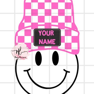 May include: A pink and white checkered beanie with a black patch that says "YOUR NAME" on top of a black and white smiley face.