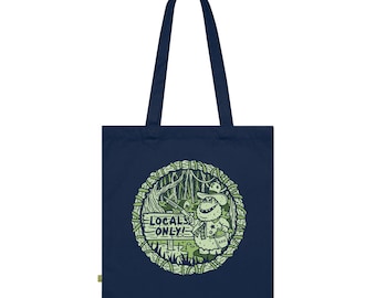 May include: A navy blue tote bag featuring a green and white illustration of a creature in a forest holding a sign that reads "Locals Only!" The illustration is encircled by a circle of green vines.
