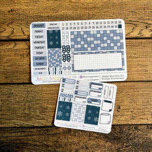 May include: Two sticker sheets for planning, featuring a Winter Wonderland theme. The larger sheet has a calendar layout with the month of January, while the smaller sheet includes appointment and to-do stickers. The stickers are in shades of blue and white.