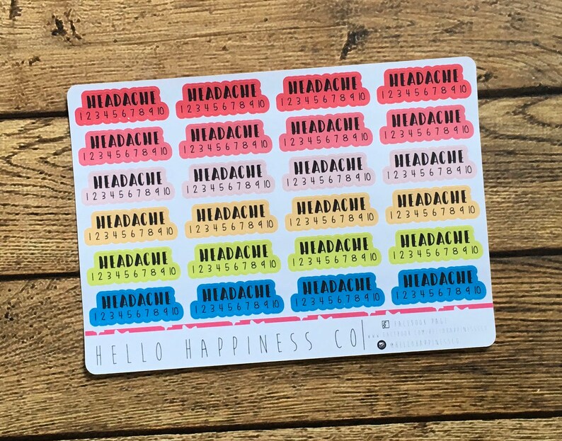 May include: A sheet of colorful stickers with the word "HEADACHE" and the numbers "1 2 3 4 5 6 7 8 9 10" repeated on each sticker. The stickers are in various colors, including pink, yellow, blue, and green. The text "HELLO HAPPINESS CO." is printed at the bottom of the sheet.