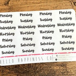 May include: A sheet of white stickers with the days of the week written in black cursive lettering. The stickers are arranged in four columns of seven stickers each. The text "HELLO HAPPINESS CO." is printed at the bottom of the sheet.