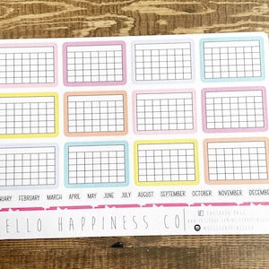 Pu&ograve; includere: Un planner mensile stampabile con 12 caselle colorate, ciascuna etichettata con un mese dell'anno. Il planner &egrave; progettato per tenere traccia delle abitudini, degli obiettivi o di altre attivit&agrave;.