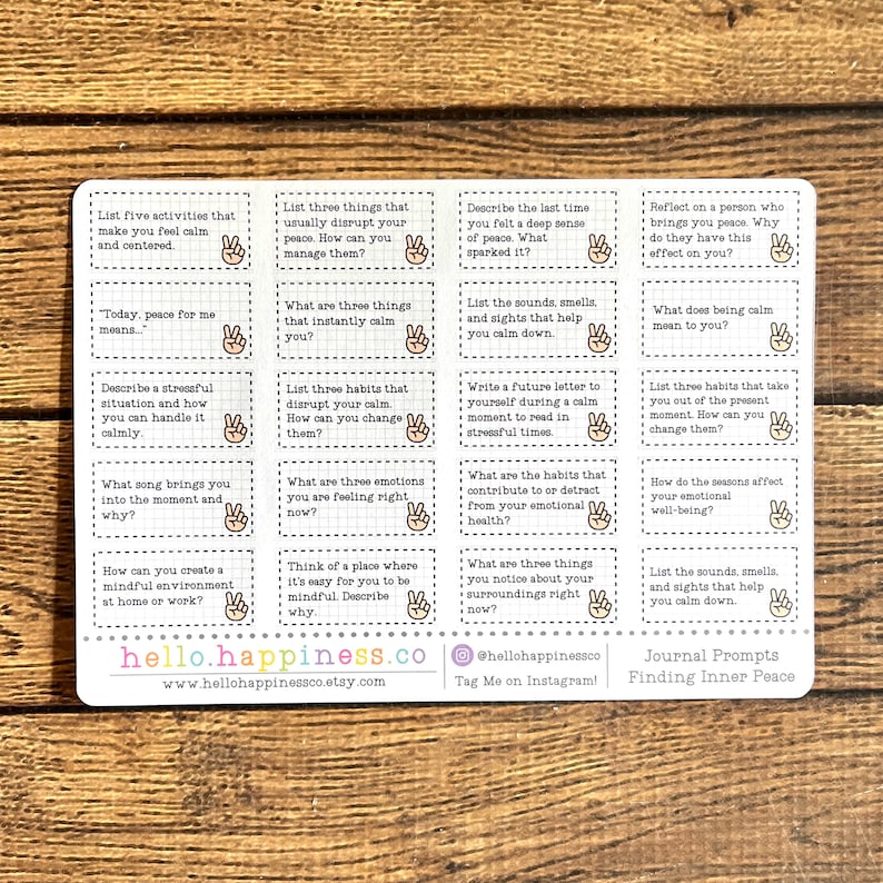 May include: A white sticker sheet with journal prompts for finding inner peace. The prompts are in small rectangular boxes with a peace sign icon. The sticker sheet has the website hello.happiness.co and the Instagram handle @hellohappinessco.