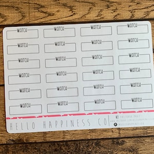 May include: A sheet of white stickers with 20 blank rectangular labels that say "WATCH" in black text. The stickers are arranged in four rows of five. The sheet has a pink line at the bottom with the text "HELLO HAPPINESS CO" in black text.