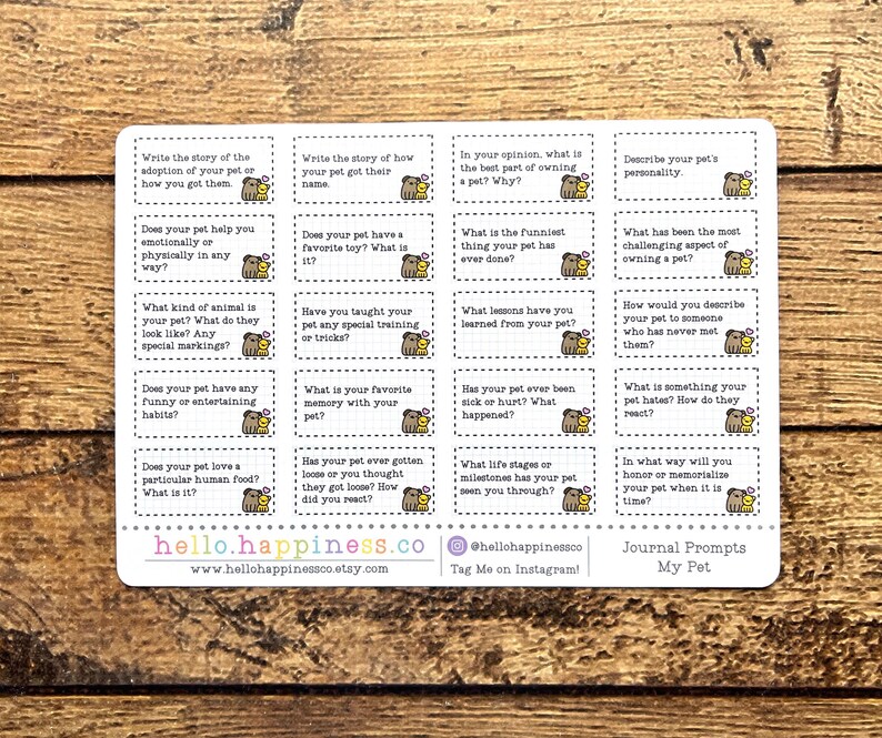 May include: A white sticker sheet with journal prompts about pets. Each prompt is in a small box with a cartoon dog illustration. The sticker sheet includes the website hello.happiness.co and the text "Journal Prompts My Pet."